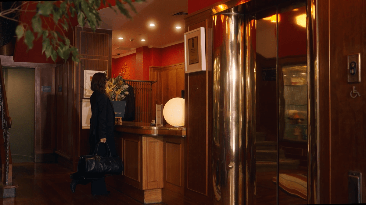 Figure entering a warmly lit boutique hotel