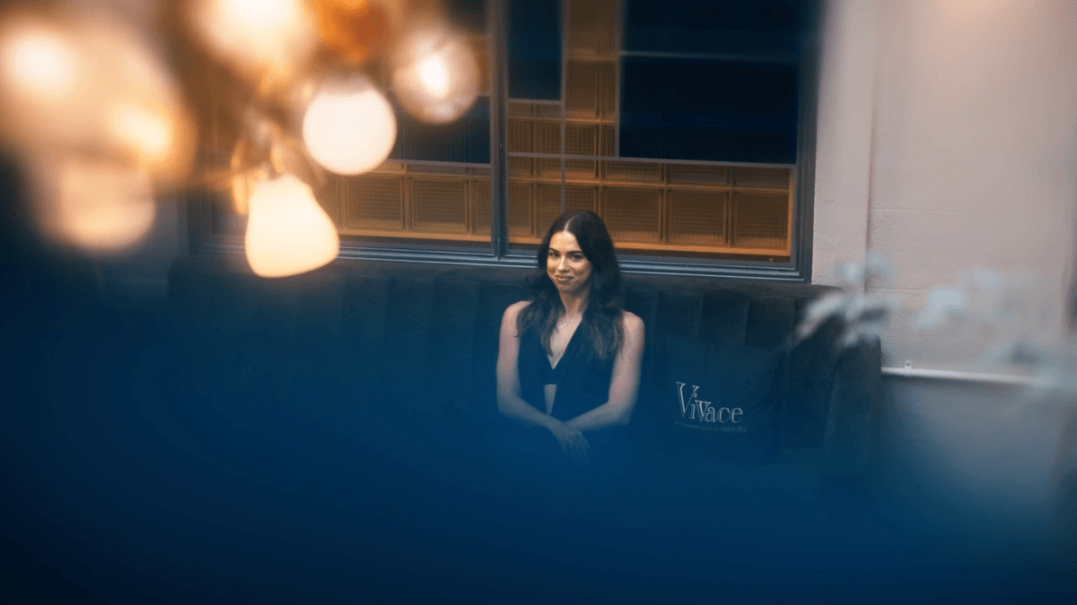 A woman seated in cinematic blue light